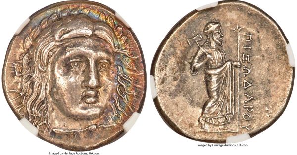 Lot 30067 > CARIAN SATRAPS. Pixodarus (ca. 341/0-336/5 BC). AR didrachm (20mm, 6.96 gm, 11h). NGC Choice AU 4/5 - 4/5, Fine Style. Laureate bust of Apollo facing, turned slightly right, hair parted in center and swept to either side, cloak fastened around neck / ΠIΞΩΔAPOY, Zeus standing right, bipennis in right hand over shoulder, scepter in left. Konuk, Coin Hoards IX, 36c (A4/P19) (this coin). SNG Copenhagen 596-7. SNG von Aulock 2375-6. Striking rainbow toning on obverse.  Ex Gemini Auction I (11 January 2005), lot 174; Commander David R. Hinkle Collection