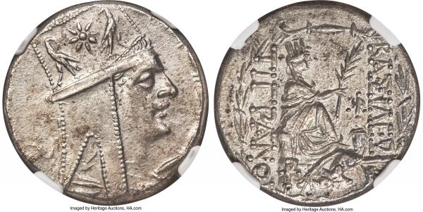Lot 30081 > ARMENIAN KINGDOM. Tigranes II the Great (95-56 BC). AR tetradrachm (26mm, 15.57 gm, 12h). NGC Choice AU 5/5 - 3/5.  Tigranocerta, ca. 80-68 BC. Diademed and draped bust right, wearing tiara with starburst between eagles standing outward looking inward, bead-and-reel border / BAΣIΛEΩΣ / TIΓPANOY, Tyche seated on rock right, holding palm, river god Orontes swimming right before, ΩI monogram in inner right field, staurogram on rock, laureate border, I in exergue. AC 34. Kovacs 71.2.