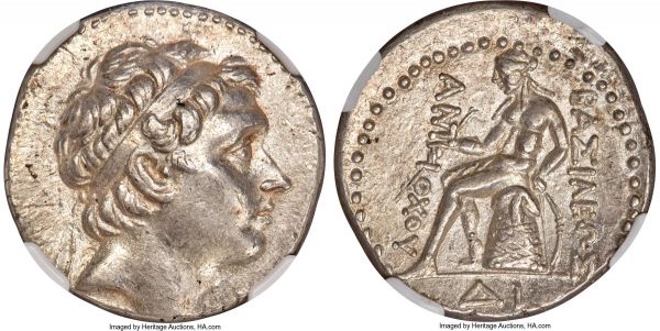 Lot 30084 > SELEUCID KINGDOM. Antiochus III the Great (222-187 BC). AR tetradrachm (26mm, 17.09 gm, 1h). NGC Choice AU 5/5 - 4/5, Fine Style. ΔΙ mint in southern or eastern Syria, from ca. 202 BC. Diademed head of Antiochus III right, idealizing, godlike portrait with mature features, softened and verging on delicate, touseled hair and slight break in bangs indicating incipient baldness at temple, horn above ear, diadem ends falling straight behind; ΔΙ behind, dotted border / BAΣIΛEΩΣ / ANT-IOXOY, Apollo seated left on omphalus, testing arrow in right hand, left hand resting on grounded bow with grip marked by three pellets at right; ΔΙ in exergue, dotted border. SC 1109.2.