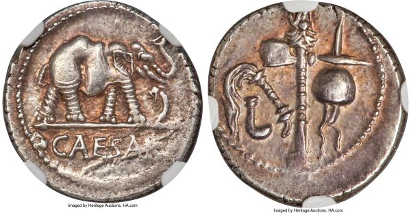 Lot 30097 > Julius Caesar, as Dictator (49-44 BC). AR denarius (19mm, 3.87 gm, 2h). NGC Choice AU 4/5 - 4/5. Military mint traveling with Caesar in northern Italy, ca. 49-48 BC. CAESAR, elephant advancing right, trampling horned serpent / Pontifical implements: simpulum, aspergillum, securis (axe surmounted by dog or wolf's head), and apex. Crawford 443/1. Sydenham 1006. Julia 9.  Ex Dr. Nicholas Lowe Collection (Roma Numismatics, Auction XVIII, 29 September 2019), lot 948; Classical Numismatic Group, Triton IX (10 January 2006), lot 1317