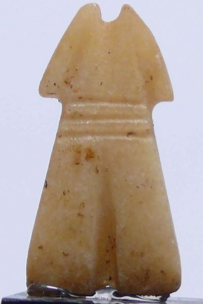 Egypte - Basse époque - Amulette en pierre - 663 / 332 av. J.-C. - (26ème-30ème dynastie) Amulette en pierre de couleur beige représentant une tunique - 30 mm.