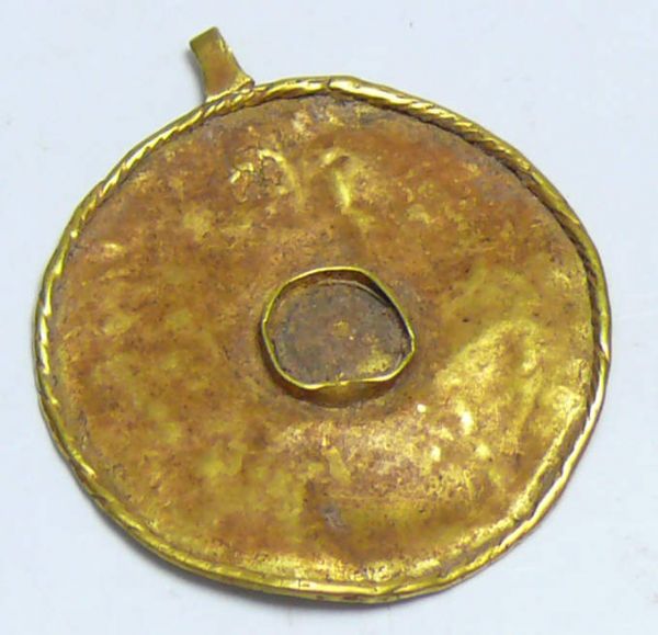 Egypto-phénicien - Pendentif en or - 1000 av. J.-C. Joli pendentif en or avec son maillon d'accroche et un petit cercle au milieu ayant peut être contenu une pierre précieuse. Poids : 1.04 gr ; 15 mm.