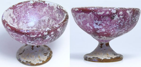 Romain - Empire d'Orient - Coupe en verre irisé - 100 / 200 ap. J.-C. Coupelle piédouche en verre irisé nacré. Verre formé de 2 épaisseurs. La coupe est de couleur violette et le pied de couleur ocre. Aucune traces de restauration. 80x60 mm.