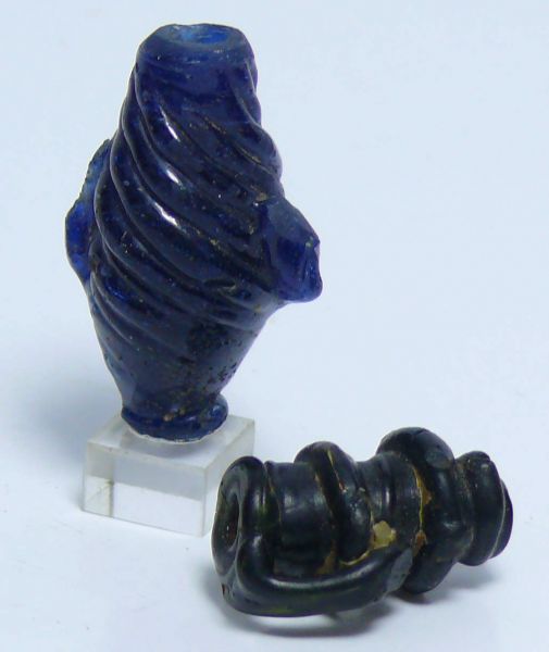 Romain - Lot de vase en pâte de verre - 200 / 400 ap. J.-C. Lot de 2  petits vases en pâte de verre, l'un en pâte de verre bleue torsadée, l'autre en pâte de verre rouge avec une petite anse. 30 et 20 mm.