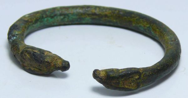 Iran - Bracelet en bronze - 1000 av. J.-C. Bracelet en bronze terminé aux extrémités, par 2 têtes de bufles, les oreilles en arrière le long des cornes arrondies comme repliées sur le dessus. Belle patine verte. Un léger manque sous l'une des têtes. 68 mm.