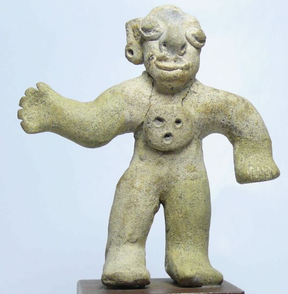 Précolombien - Statuette en terre cuite - 1000 ap. J.-C. Statuette en terre cuite de couleur blanche représentant un homme debout. Le personnage, aux yeux et au nez proéminents, porte une boucle d'oreille percée et un large médaillon sur la poitrine. Le médaillon est percé de 3 trous comme pour représenter 2 yeux et un nez. Les bras du personnages ont été recollés au corps et il manque l'oreille gauche. 105 mm.