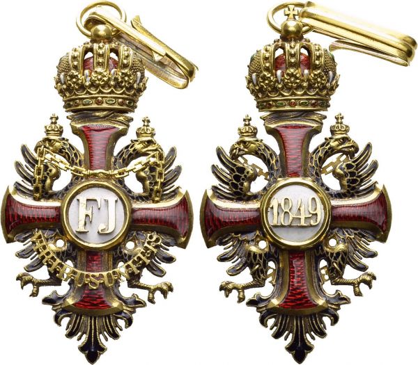Franz Joseph I, 1848-1916. Imperial Order of Franz Joseph (founded 1849). Badge of Grand Cross or of Commander in gold, 37.5 x 69 mm (without rings). Mericka XLIIa (p. 108 ff). AU. 24.10 g. XF  Hallmarks of Vinc. Mayer in Vienna and for 750 gold. With fragments of civil commander's ribbon.  
